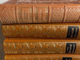 several old books stacked on top of each other on a table