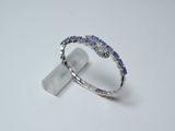 a close up of a diamond and sapphire ring on a white surface