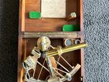 an old wooden box with a brass sexet and other items in it