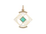 un pendentif en or orné d'une pierre verte au centre
