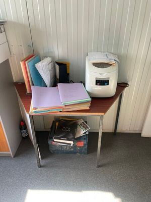 un petit bureau sur lequel se trouvent une imprimante et des livres