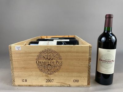 deux bouteilles de vin dans un coffret en bois à côté d'une bouteille de vin