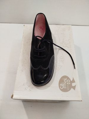 une chaussure noire posée sur une boîte