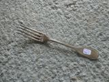 a fork with a sticker on it laying on the ground