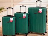 trois bagages posés sur un plancher en bois