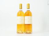 deux bouteilles de vin posées l'une à côté de l'autre sur une surface blanche