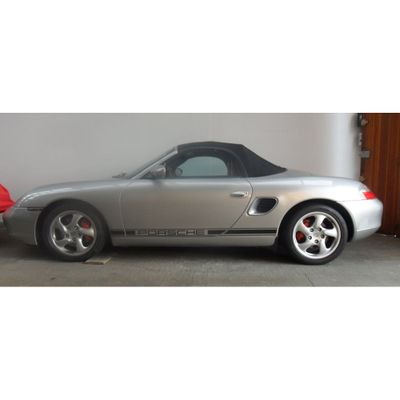 une voiture de sport argentée garée dans un garage à côté d'une voiture rouge