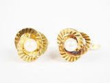 une paire de boucles d'oreilles en or et perles sur fond blanc
