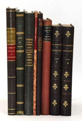 plusieurs vieux livres sont alignés sur une surface blanche