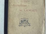 un vieux livre posé sur une table blanche à côté d'un livre noir