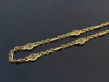 a close up of a gold chain on a black surface
