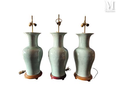 trois vases verts posés sur un support en bois