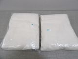 two bags of white cloth sitting on top of a table