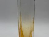 a glass vase with a yellow liquid inside of it