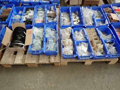 Des cartons contenant des articles variés sont empilés sur des palettes dans un entrepôt.