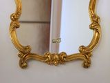 a gold mirror hanging on a wall in a room