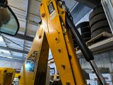 a large yellow excavator that is inside of a building