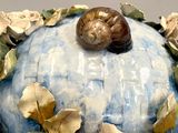 a blue and white vase with a snail on it