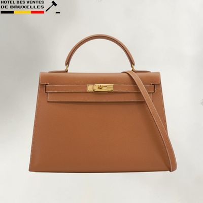 un sac à main Hermès marron avec des finitions dorées sur la poignée