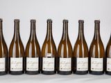 six bouteilles de vin sont alignées sur une table