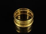 a close up of a gold ring on a black surface