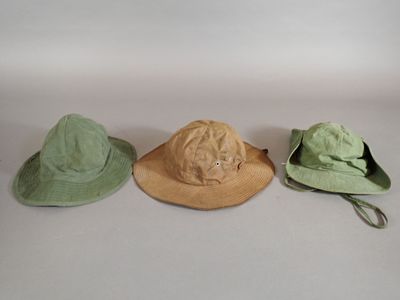 three hats are lined up in a row on a white surface