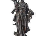 une statue antique en bronze représentant une femme tenant un enfant dans ses bras