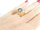 a woman ' s hand holding a ring with a diamond on it