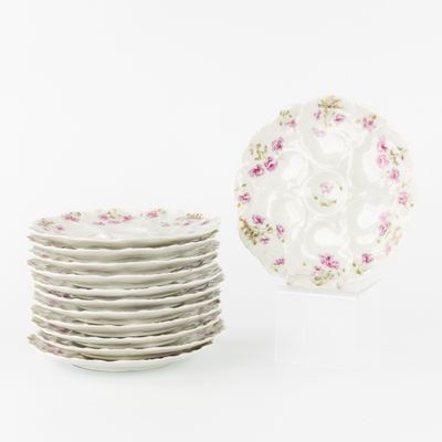une pile d'assiettes blanches ornées de fleurs roses