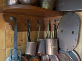 de nombreuses casseroles et poêles accrochées au mur de la cuisine