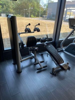 vue d'une salle de sport équipée d'appareils et dotée d'une grande fenêtre
