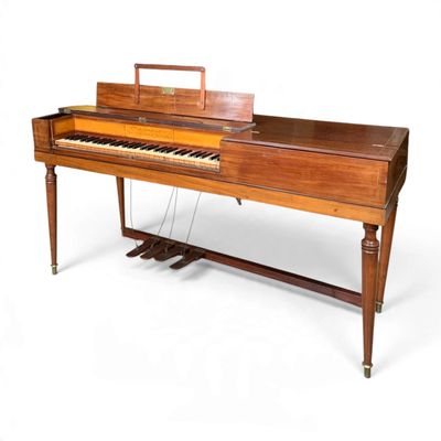 an old piano with a wooden case sitting on top of a table