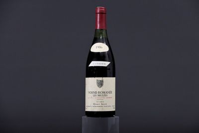a bottle of wine sitting on top of a table next to a glass