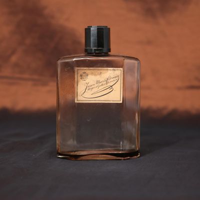 une image représentant un flacon de parfum posé sur une table