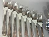 a lot of forks and spoons that are on the table