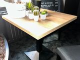 a small table with plants on it in the corner of a room