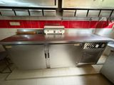 stainless steel counter top in a commercial kitchen with red tile walls