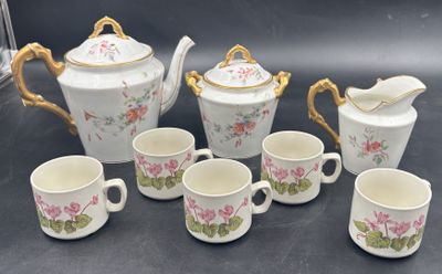 five cups and a teapot and a pitcher on the table
