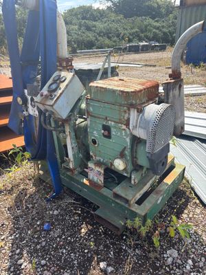 une machine posée par terre à côté d'un tas de ferraille