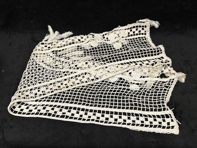 un gros plan d'un tissu blanc au crochet posé sur une surface noire
