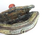 a small metal box with a red bead in it