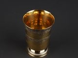 a silver cup with a gold rim on a black background
