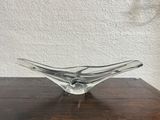 a glass bowl on a wooden table with a white wall in the background