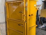 une grosse machine jaune qui se trouve dans un entrepôt