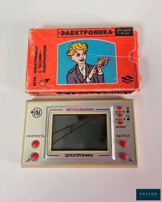 a small electronic game that is sitting next to a box