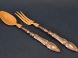 two forks and spoons sitting next to each other on a table