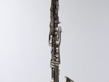 an old saxophone hanging from a string on a wall