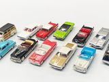 several toy cars are lined up in a row on a white surface