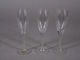 three wine glasses sitting next to each other on a table