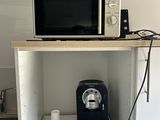 un micro-ondes et une cafetière posés sur une petite étagère
